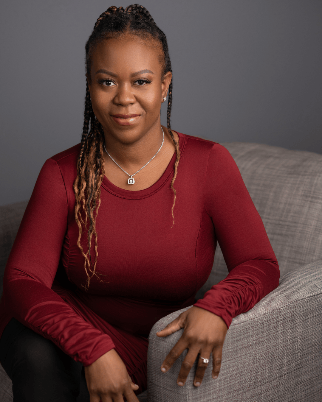 A woman sitting on top of a couch in front of a wall.